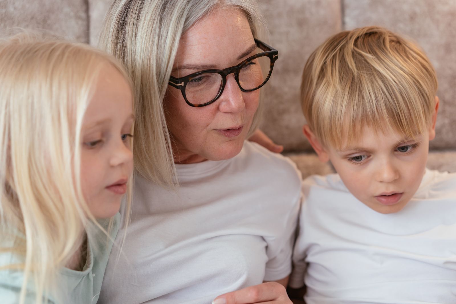 A grandmother talking with two grandchildren at home