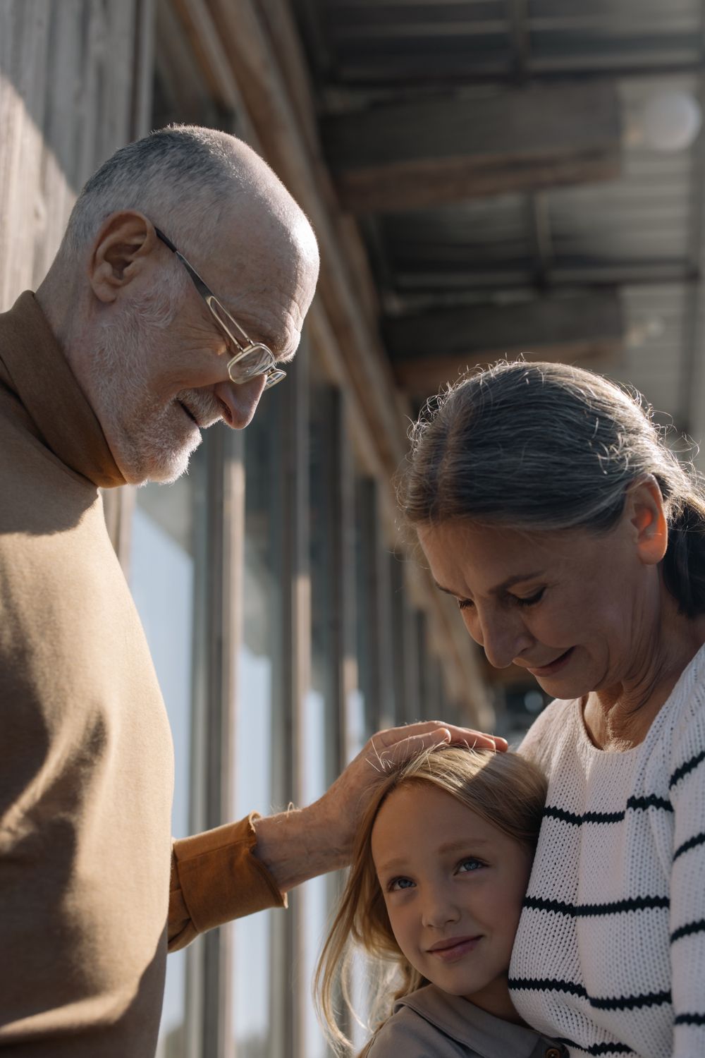 Grandparents sharing a quiet, affectionate moment with their granddaughter